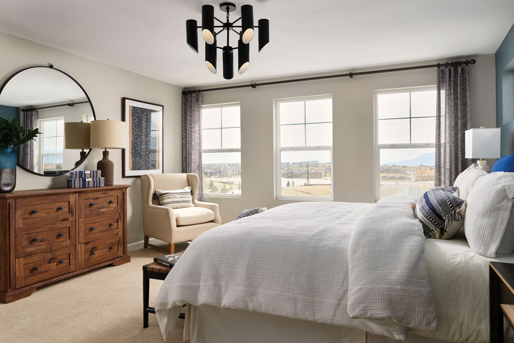 A master bedroom with three big windows and black metal details