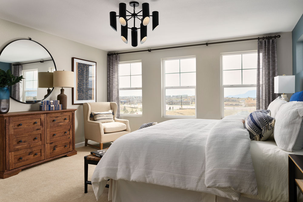 A master bedroom with three big windows and black metal details