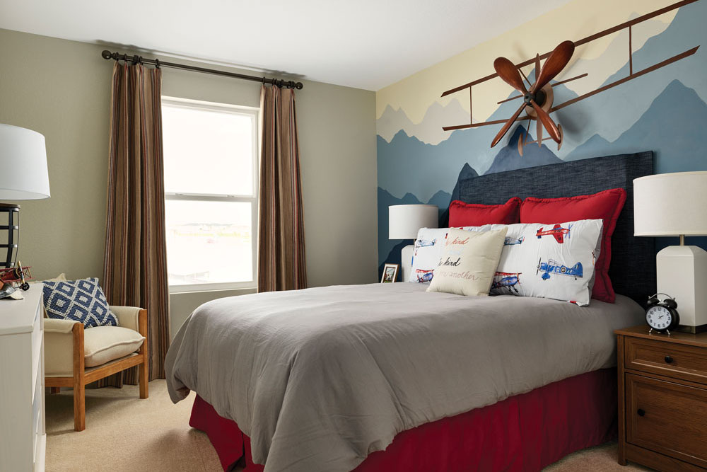 Guest bedroom with a painted accent wall and stylized furniture
